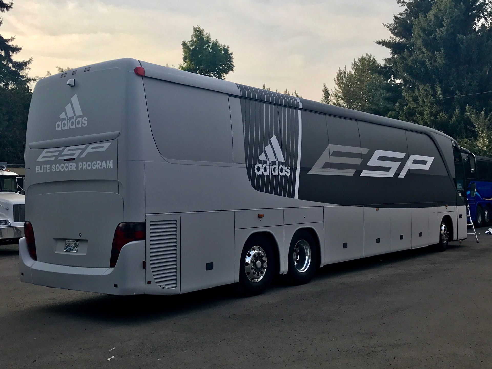 Grey Adidas ESP bus parked outdoors.