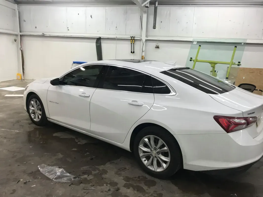 White car in a garage with tinted windows.