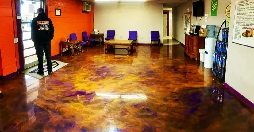 Person standing inside a waiting room with a reflective, colorful epoxy floor.