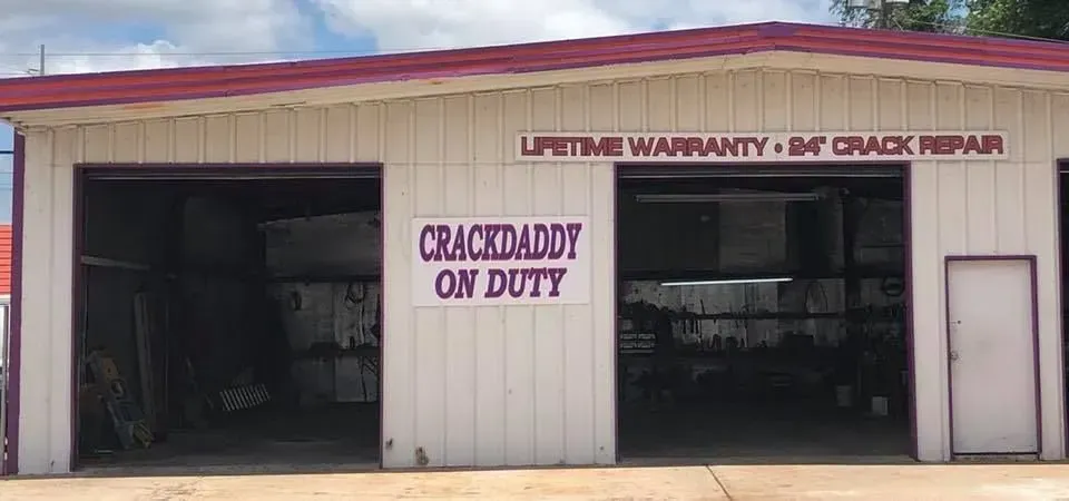 A building with garage doors. Sign reads 
