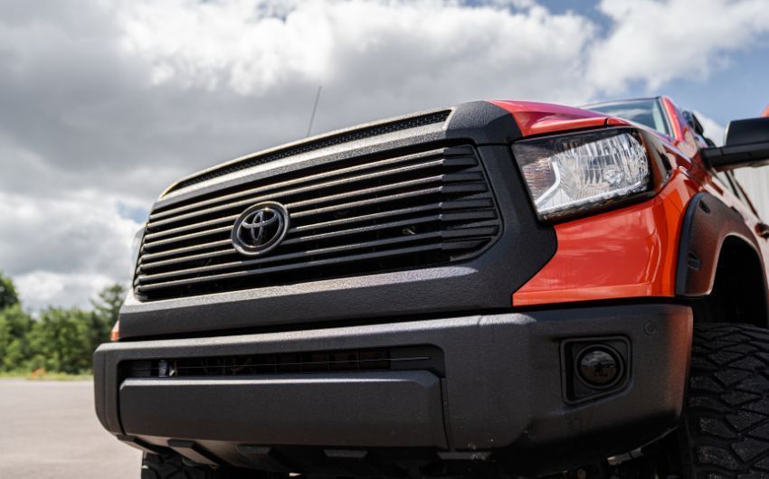 A close up of the front of a red toyota tundra truck.