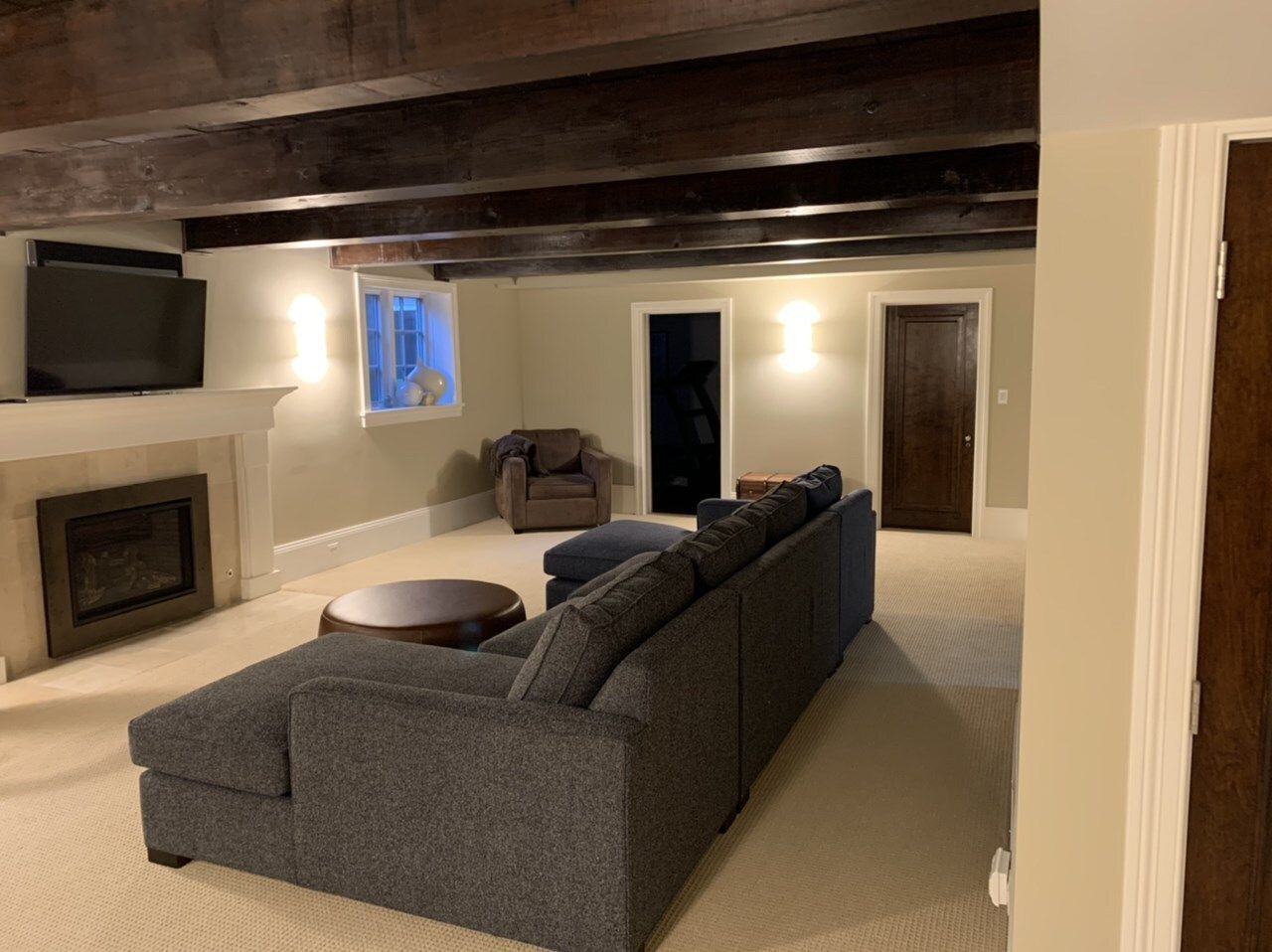 A living room with a couch, chairs, fireplace and television
