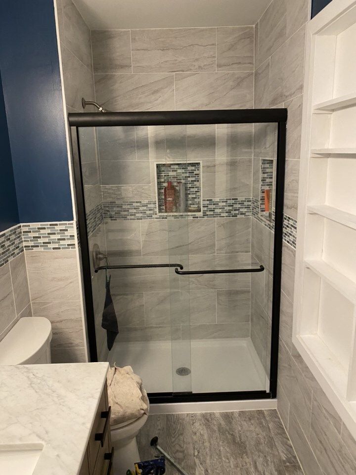 A bathroom with a sliding glass shower door and a toilet