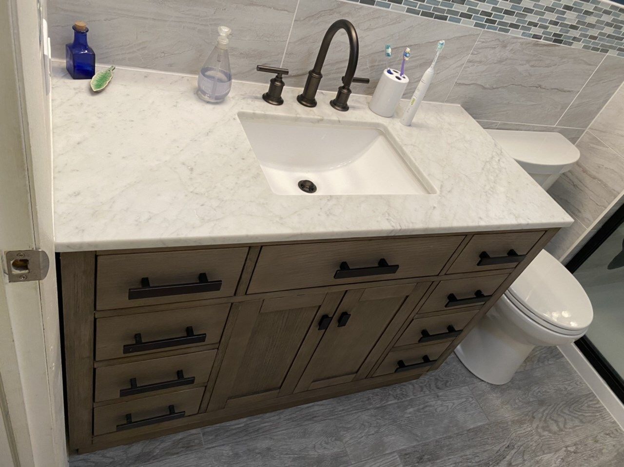 A bathroom with a sink, toilet and drawers