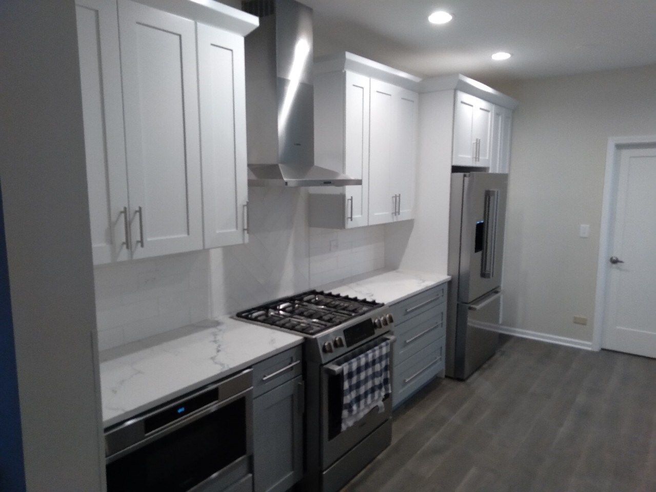 A kitchen with white cabinets and stainless steel appliances