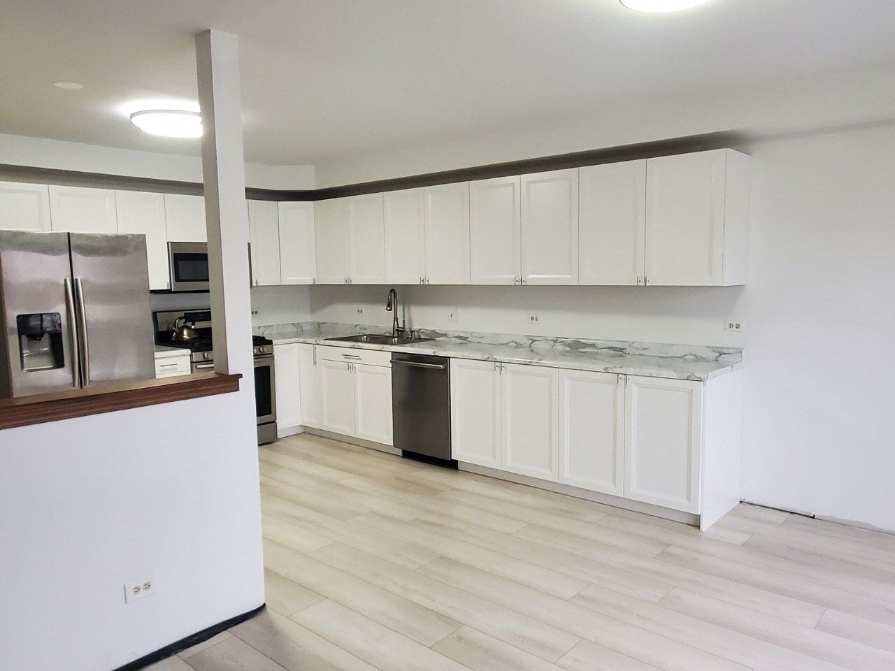 A kitchen with white cabinets and stainless steel appliances