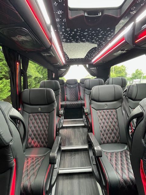 Luxury van interior with black and red leather seats and a starry LED ceiling