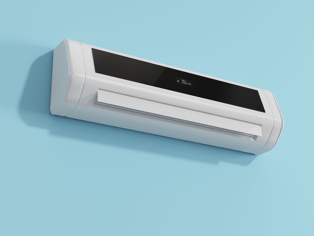 White wall-mounted air conditioning unit on a light blue wall, near a wooden ceiling.