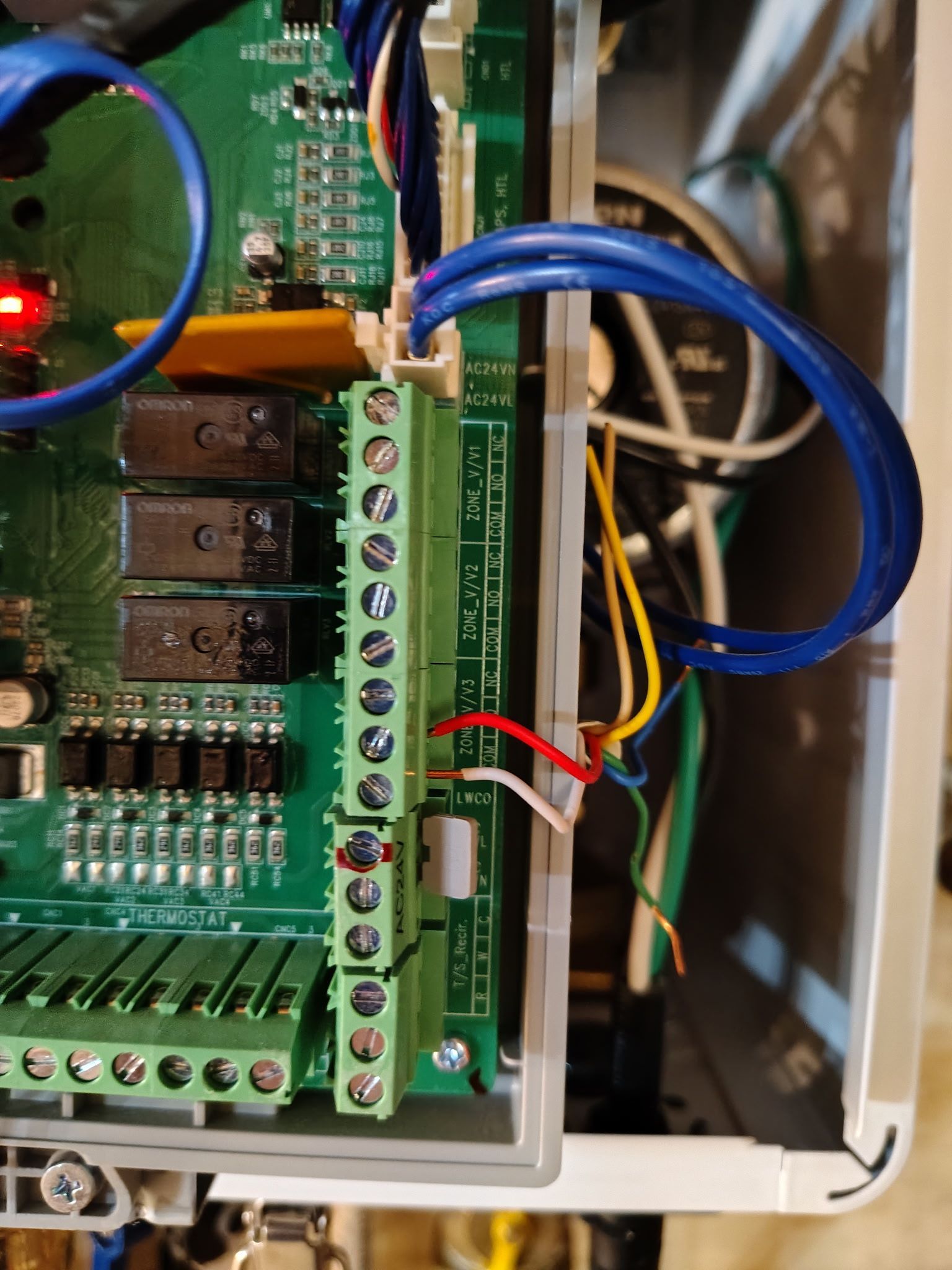 Green circuit board with terminals, wires, and a red LED.