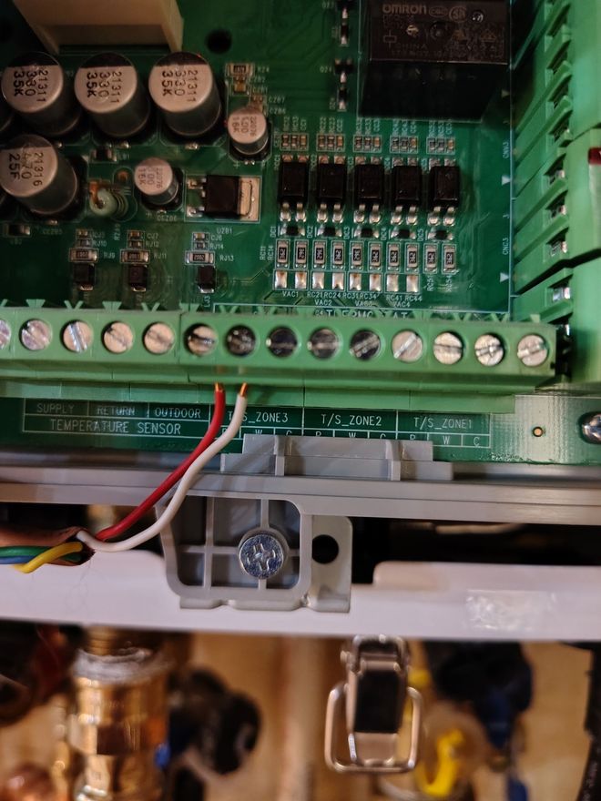Printed circuit board with wiring connections; white, red, and yellow wires visible.