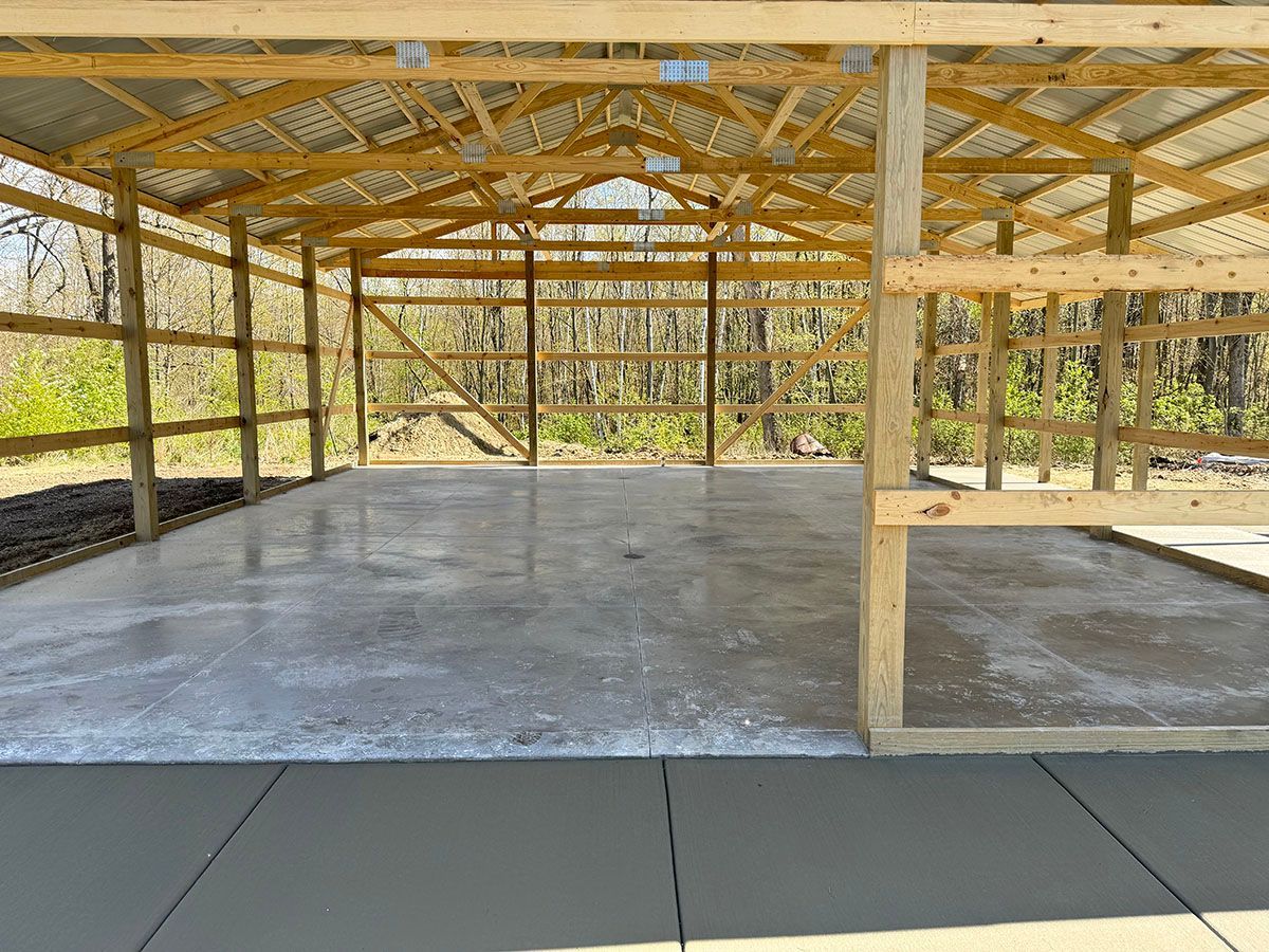 The inside of a wooden building with a concrete floor