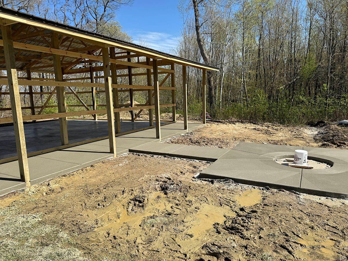 A wooden structure is being built in the middle of a dirt field