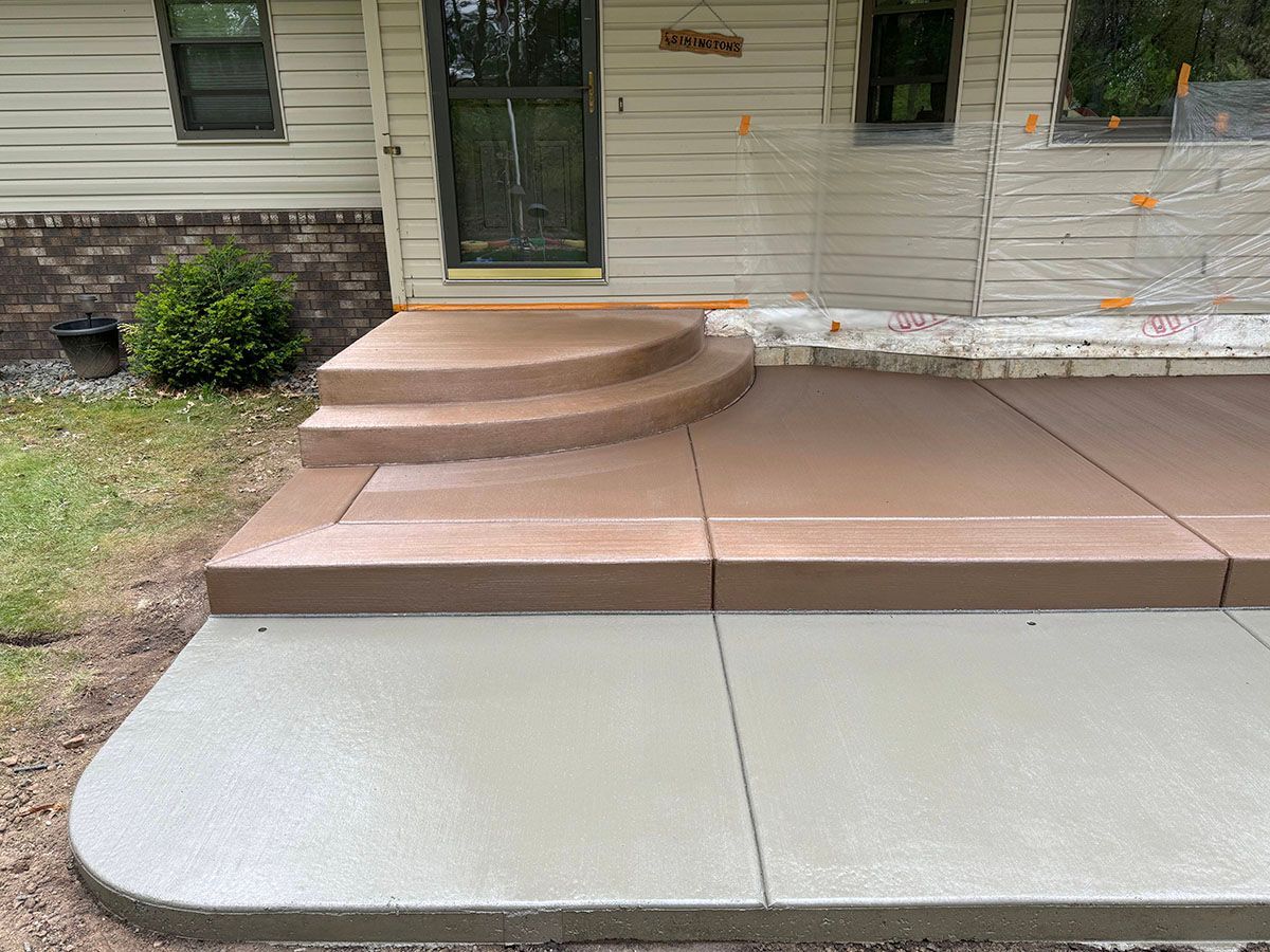 A concrete walkway with steps leading up to a house