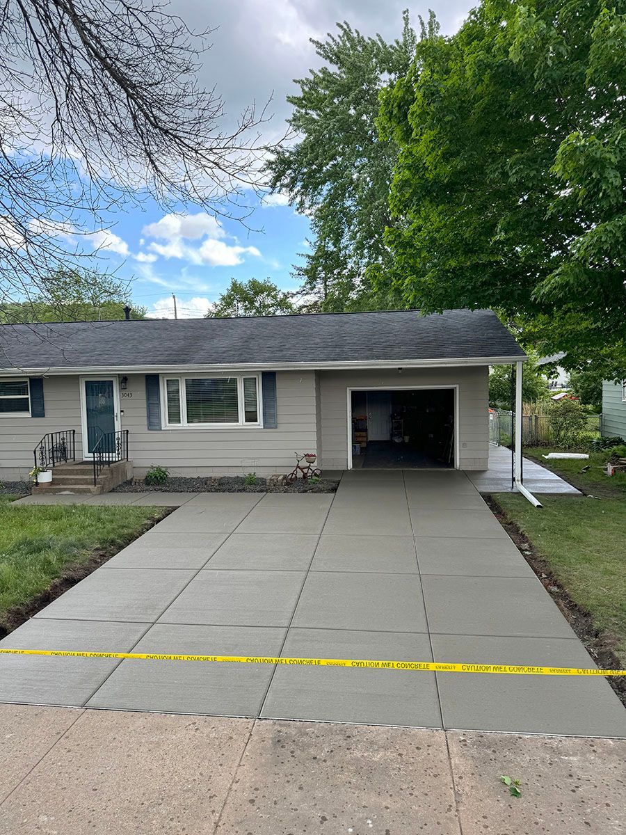 A house with a concrete driveway in front of it