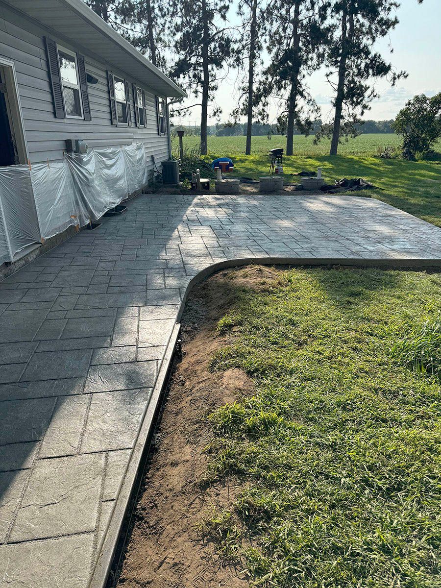 A concrete patio is being built in front of a house