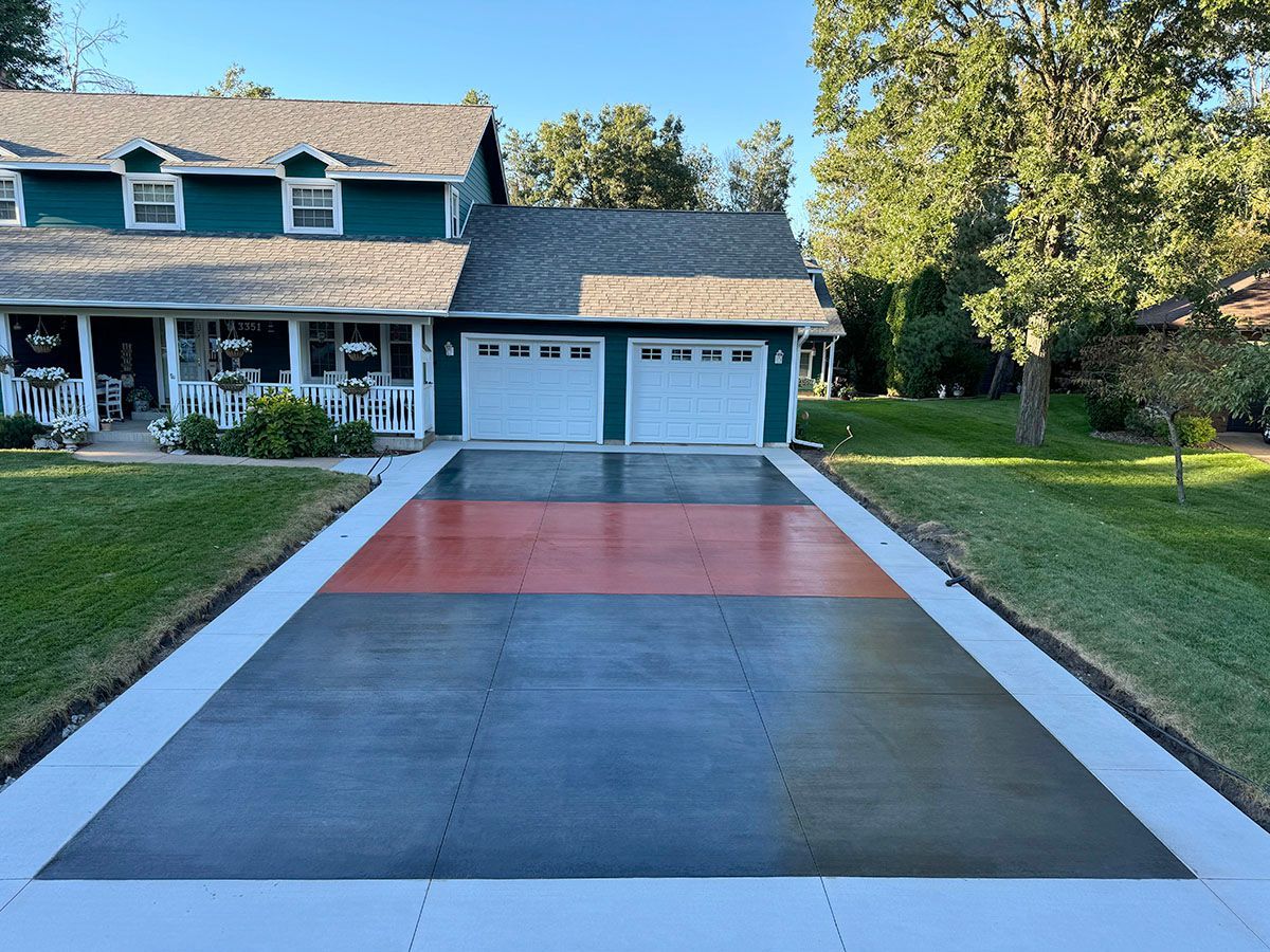 A concrete stylish driveway is being installed in front of a house