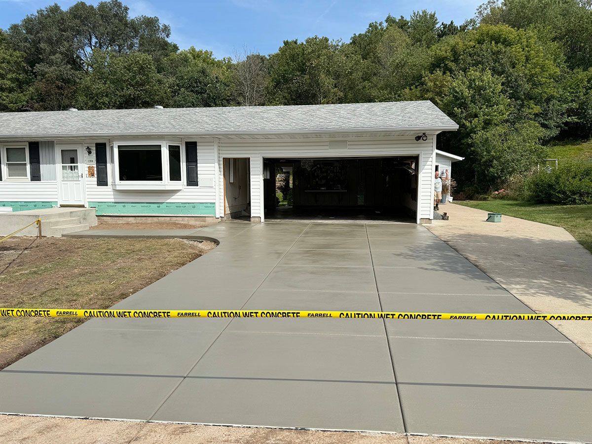 A sturdy concrete driveway is being installed in front of a house