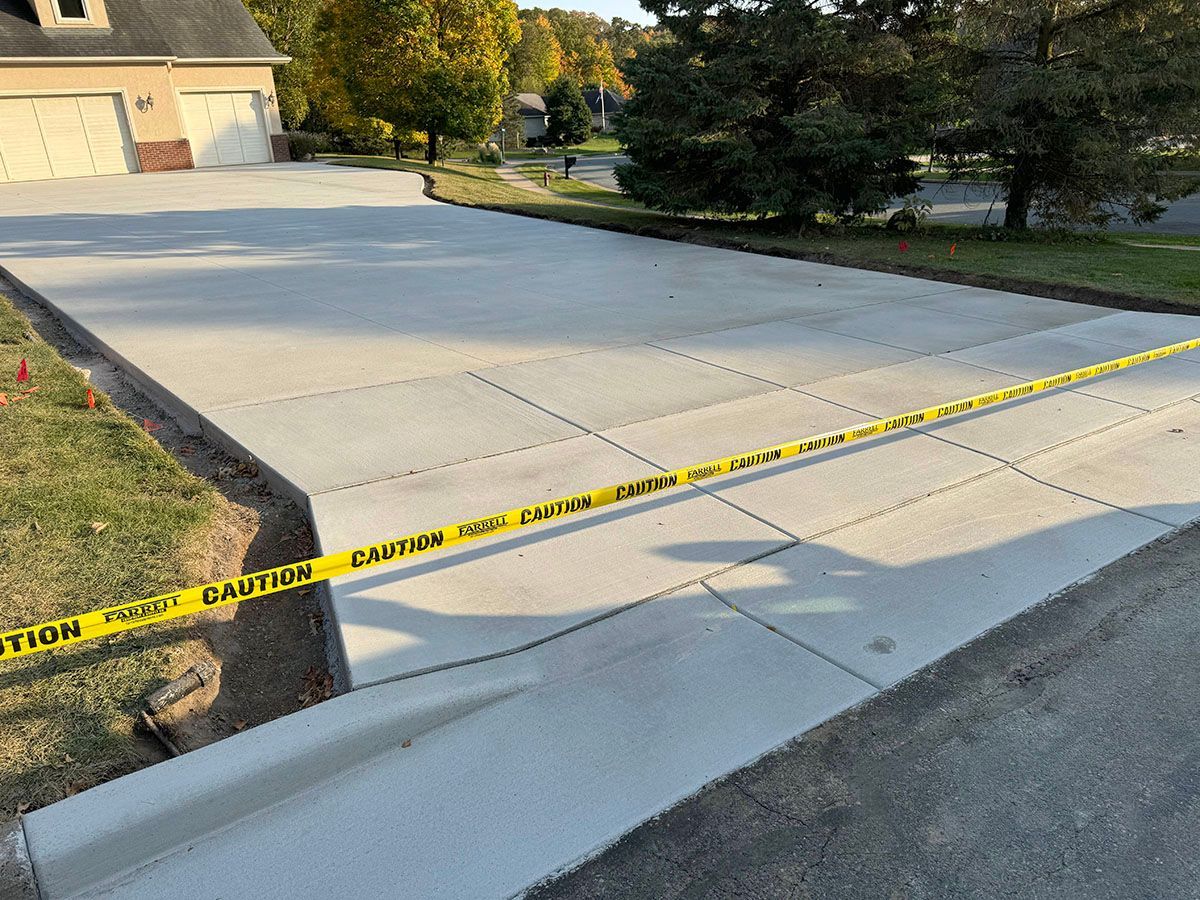 A thick concrete driveway with a yellow caution tape on it