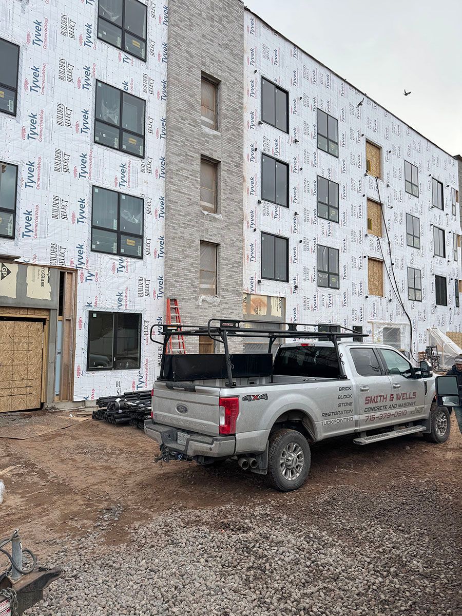 A truck is parked in front of a building under construction