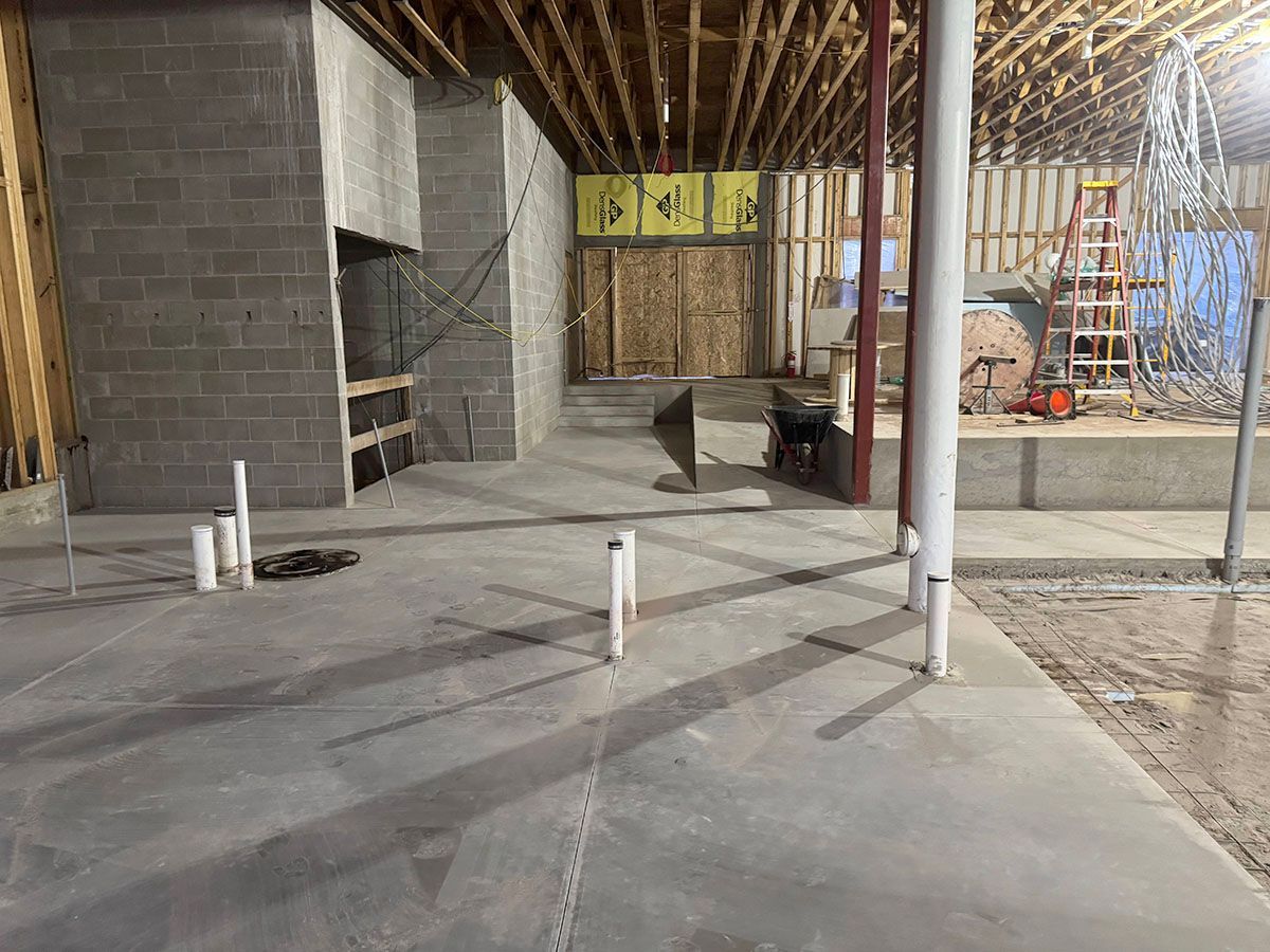 A building under construction with a lot of pipes on the floor.