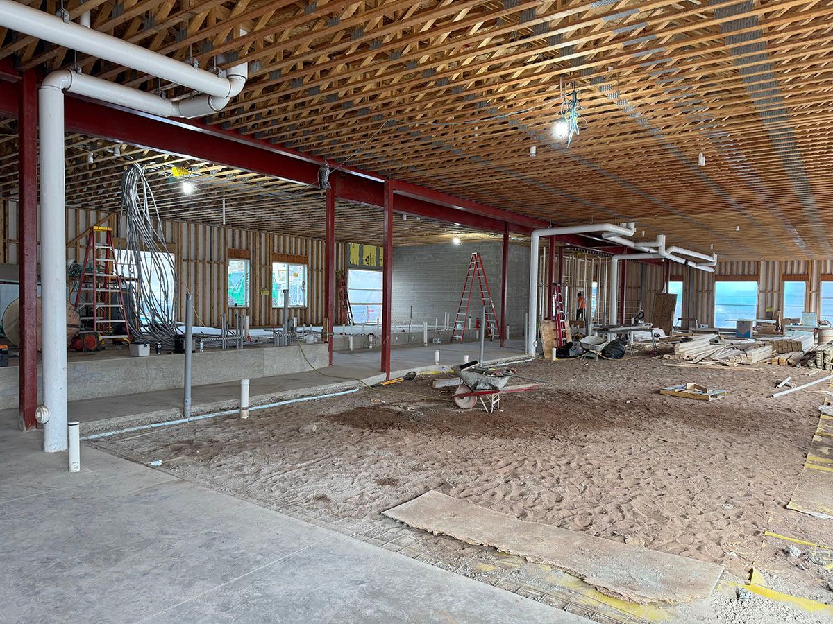 A large room with a wooden ceiling and a lot of windows under construction