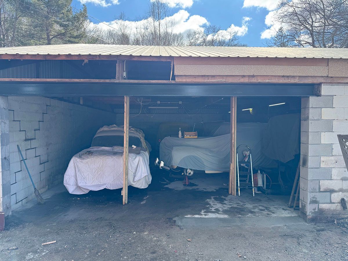 A car is parked in a garage under a roof