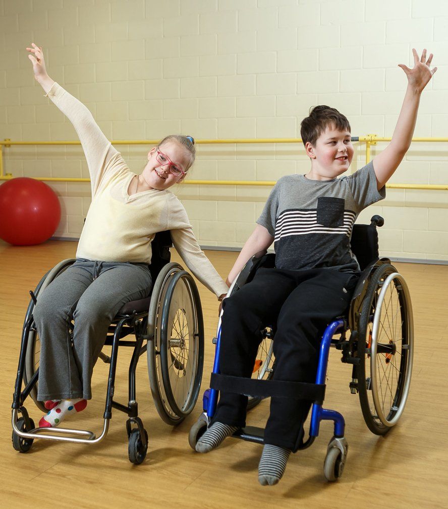 Two happy children in wheelchair