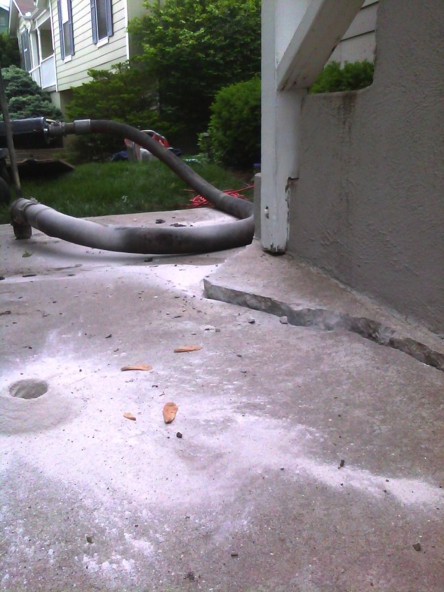 A hose is laying on the ground next to a house
