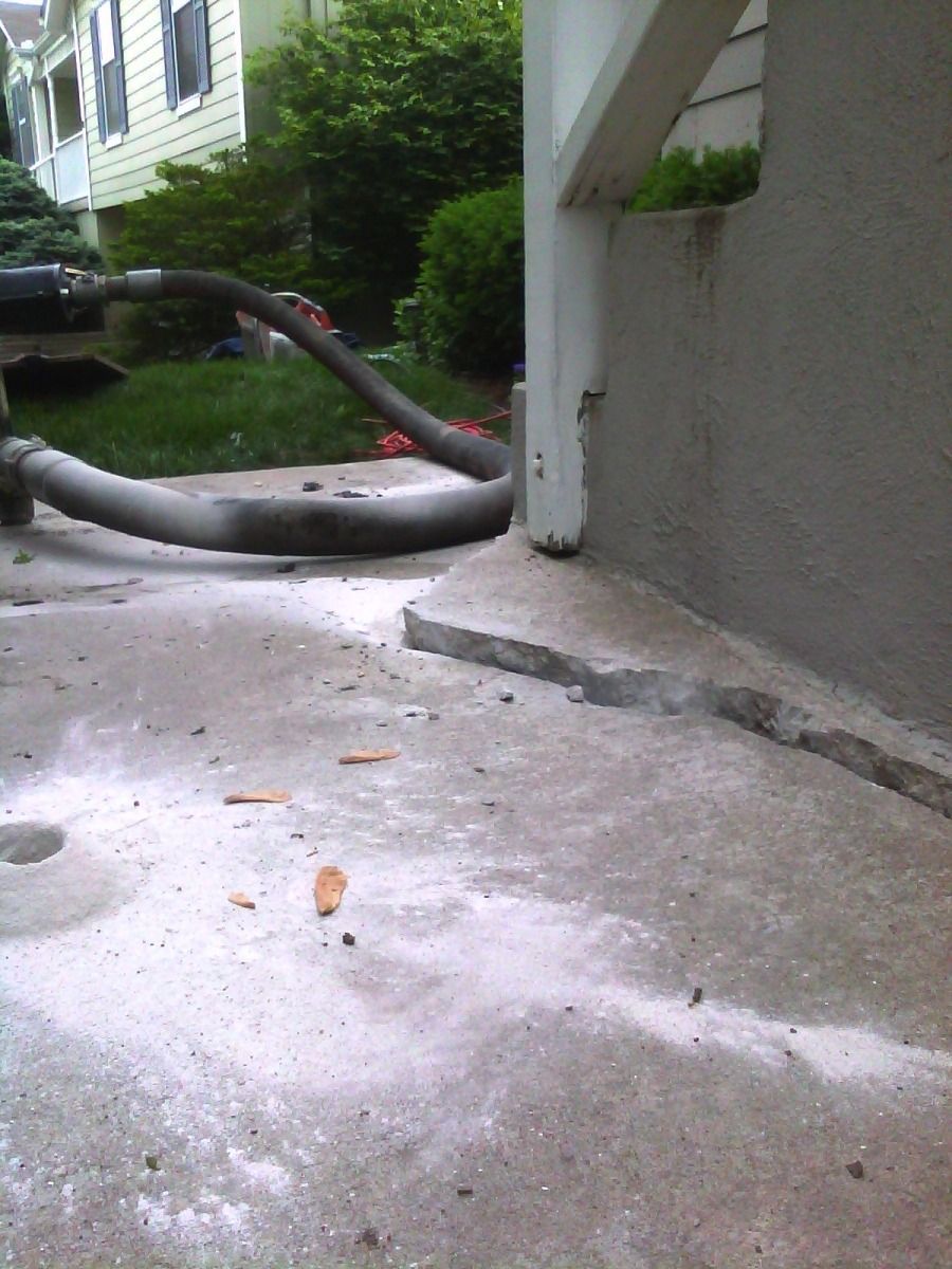 A hose is laying on the ground in front of a house