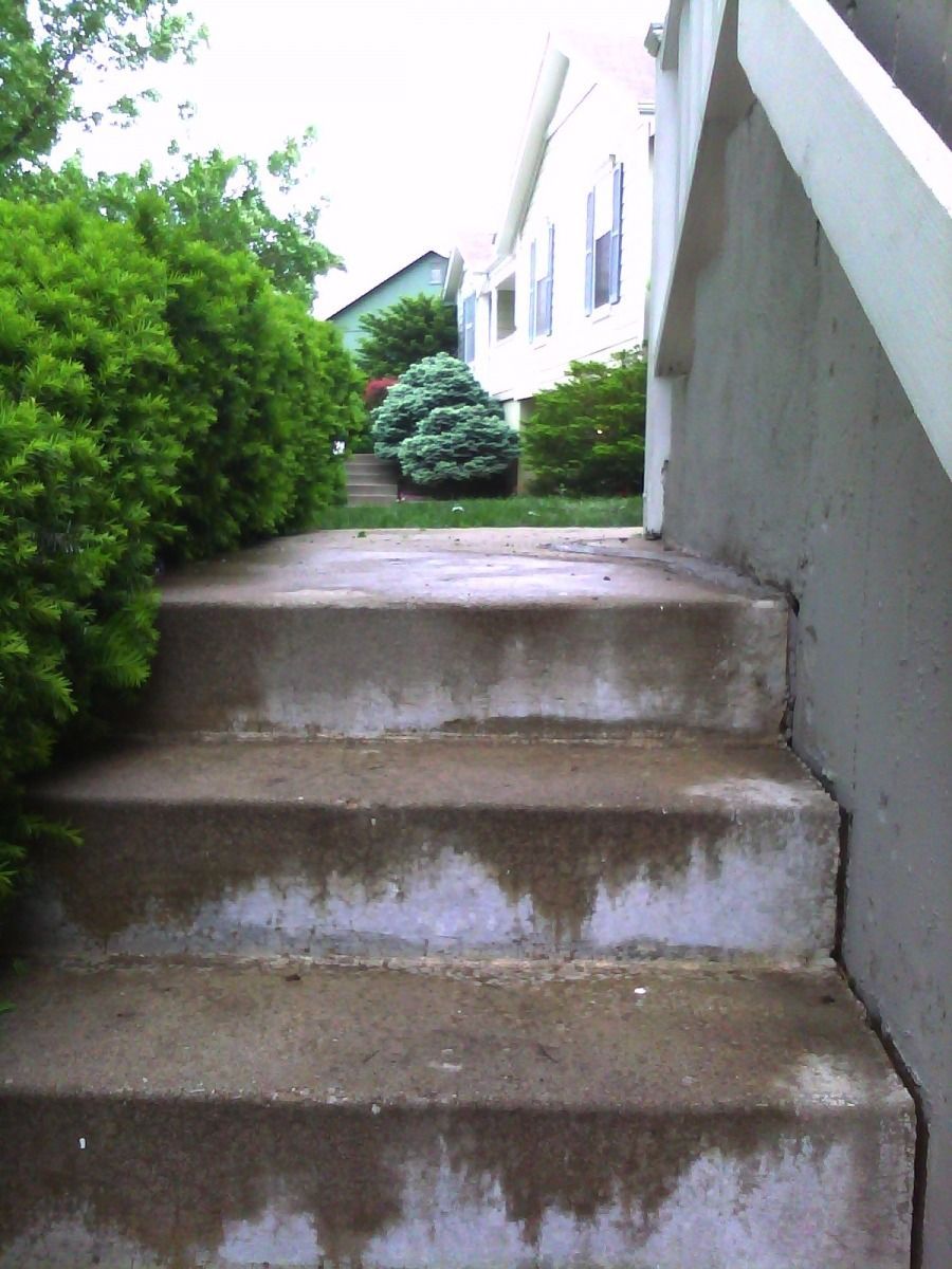 A set of concrete stairs leading up to a house