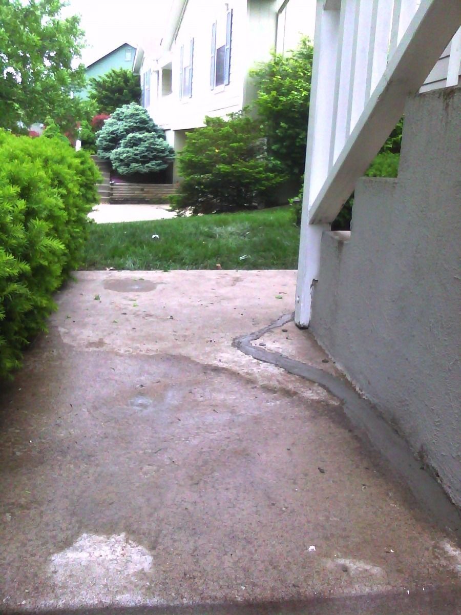 A concrete walkway leading to a white house