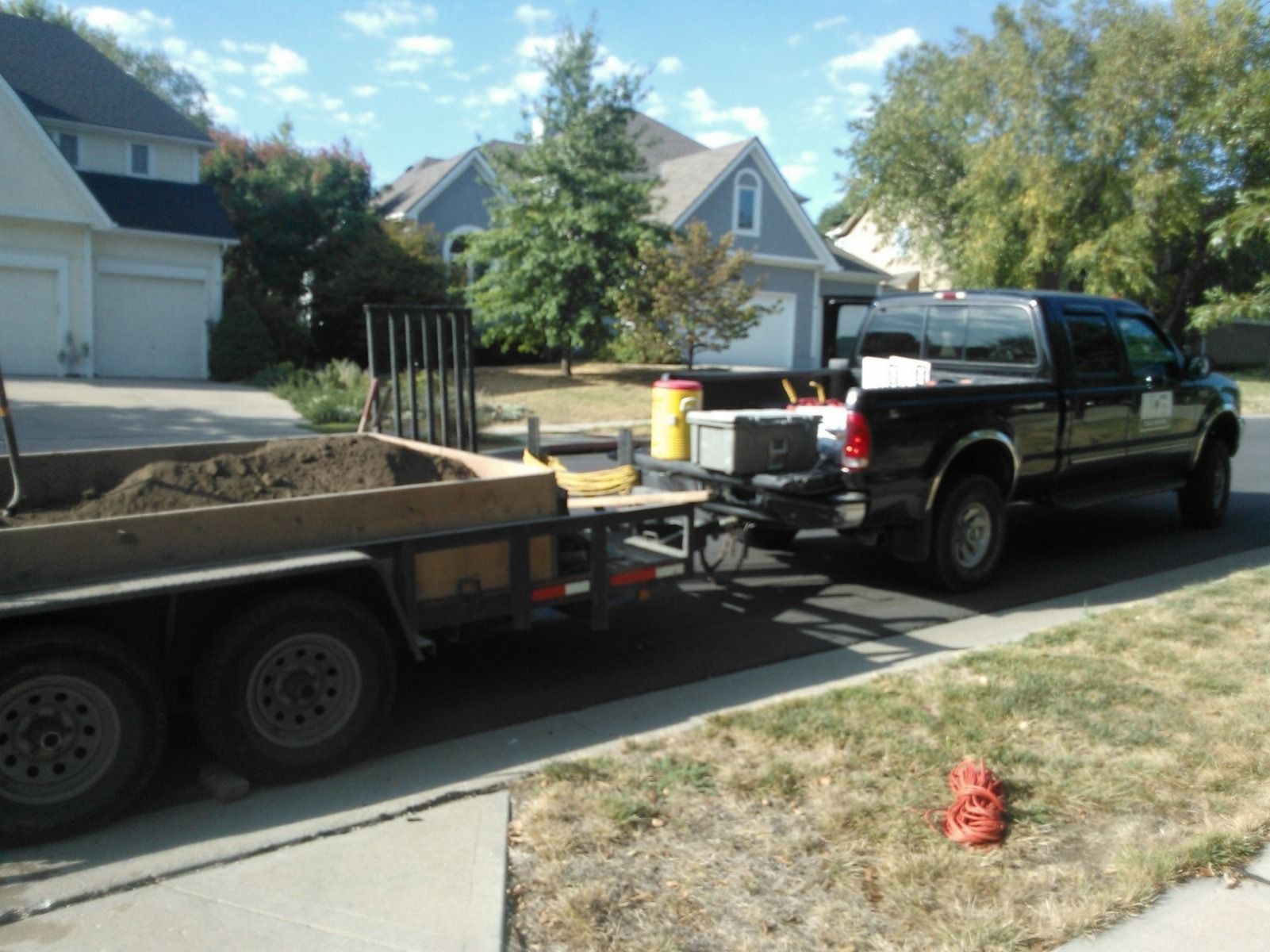 A truck is pulling a trailer full of dirt