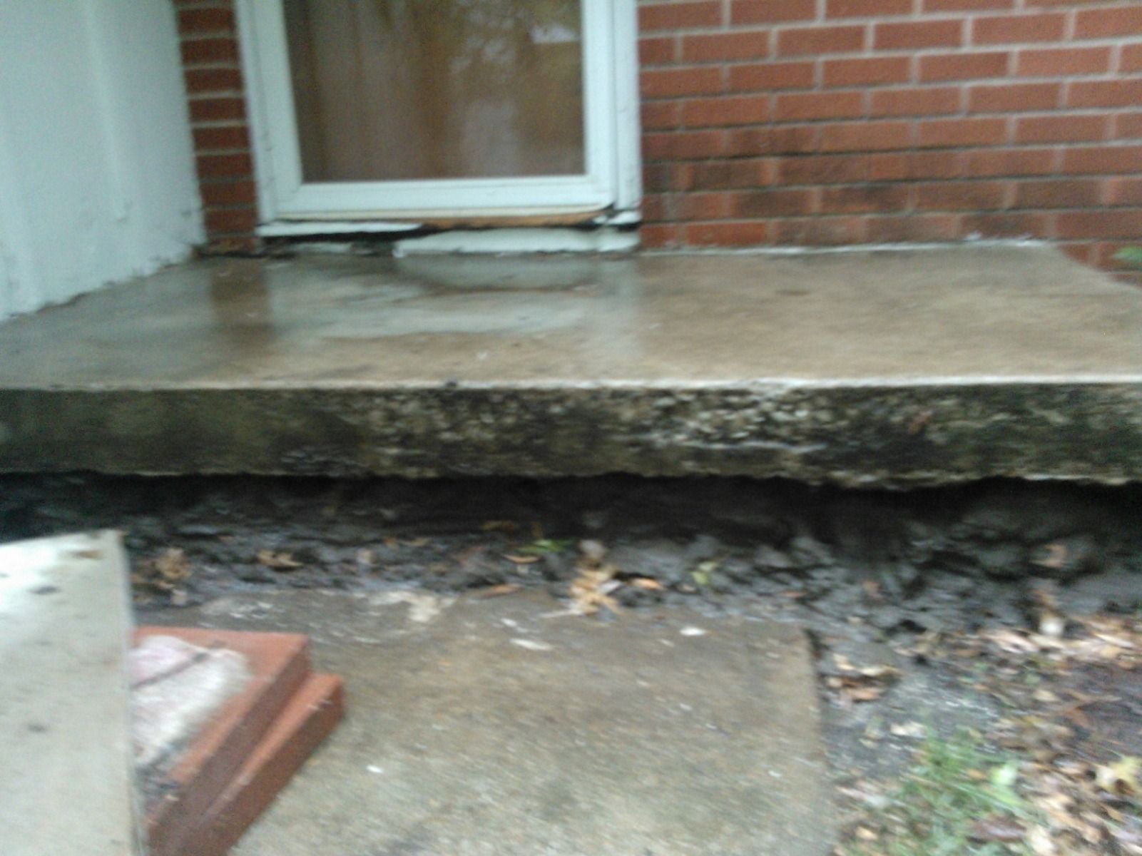 A brick building with a concrete porch in front of it