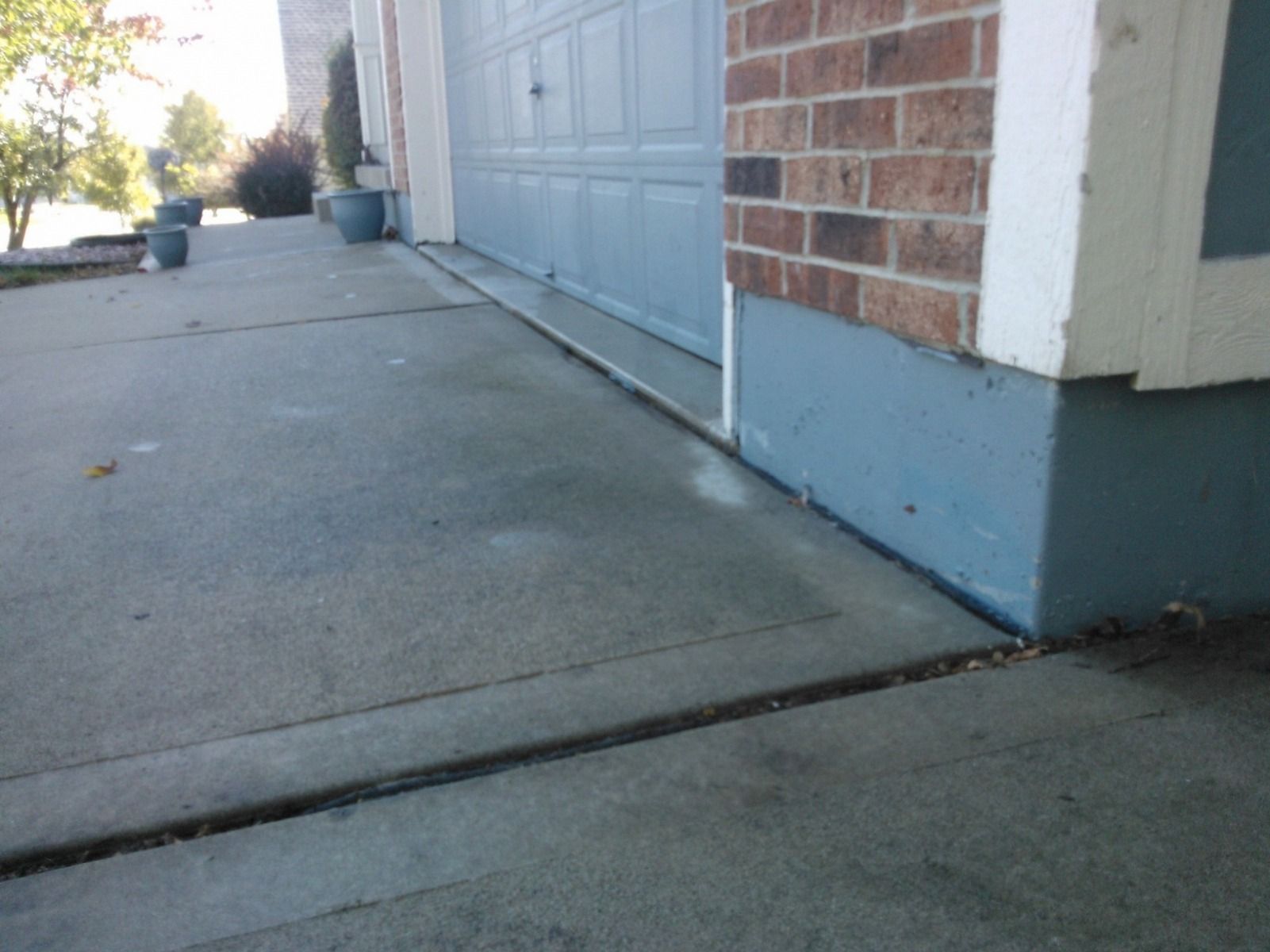 A brick house with a blue garage door and a concrete walkway