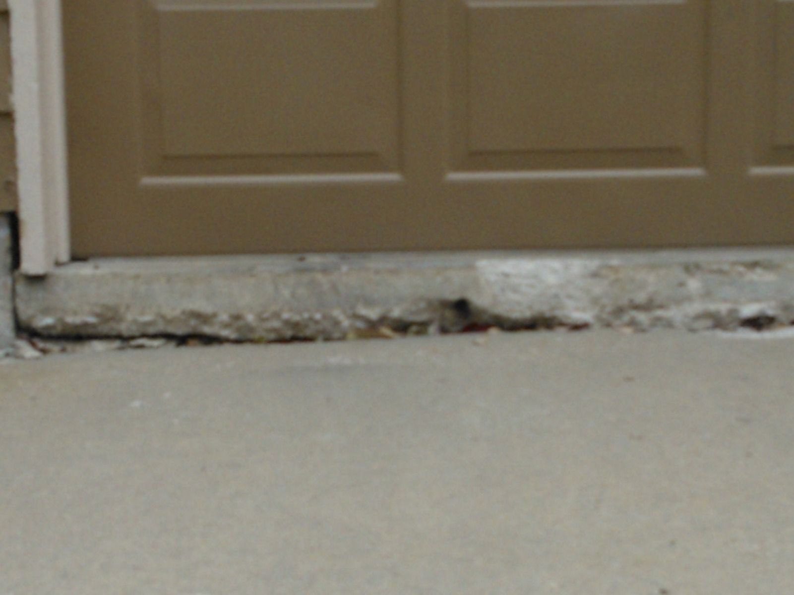 A close up of a door with a concrete floor in front of it.