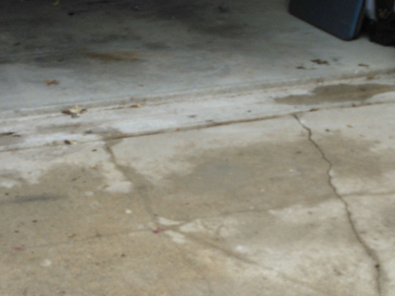 A close up of a cracked concrete floor in a garage