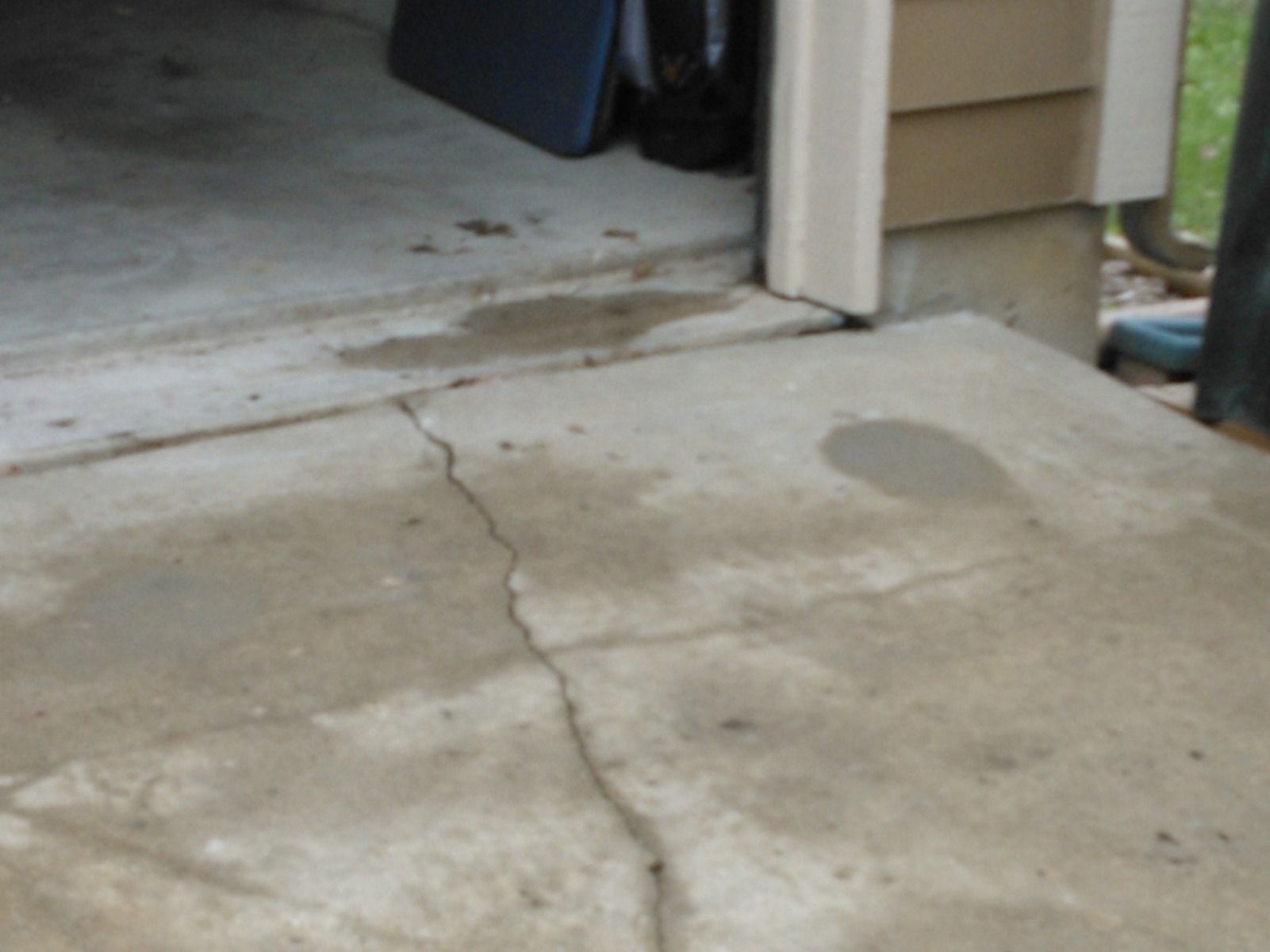 A cracked concrete floor in front of a garage door