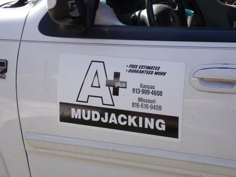 A white truck with a bumper sticker that says a+ mudjacking