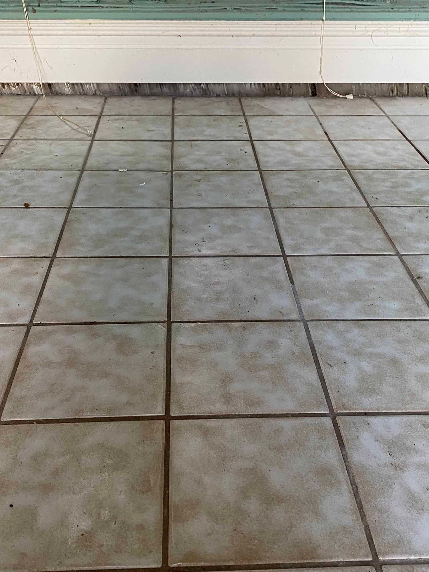 A close up of a tiled floor with a window in the background.