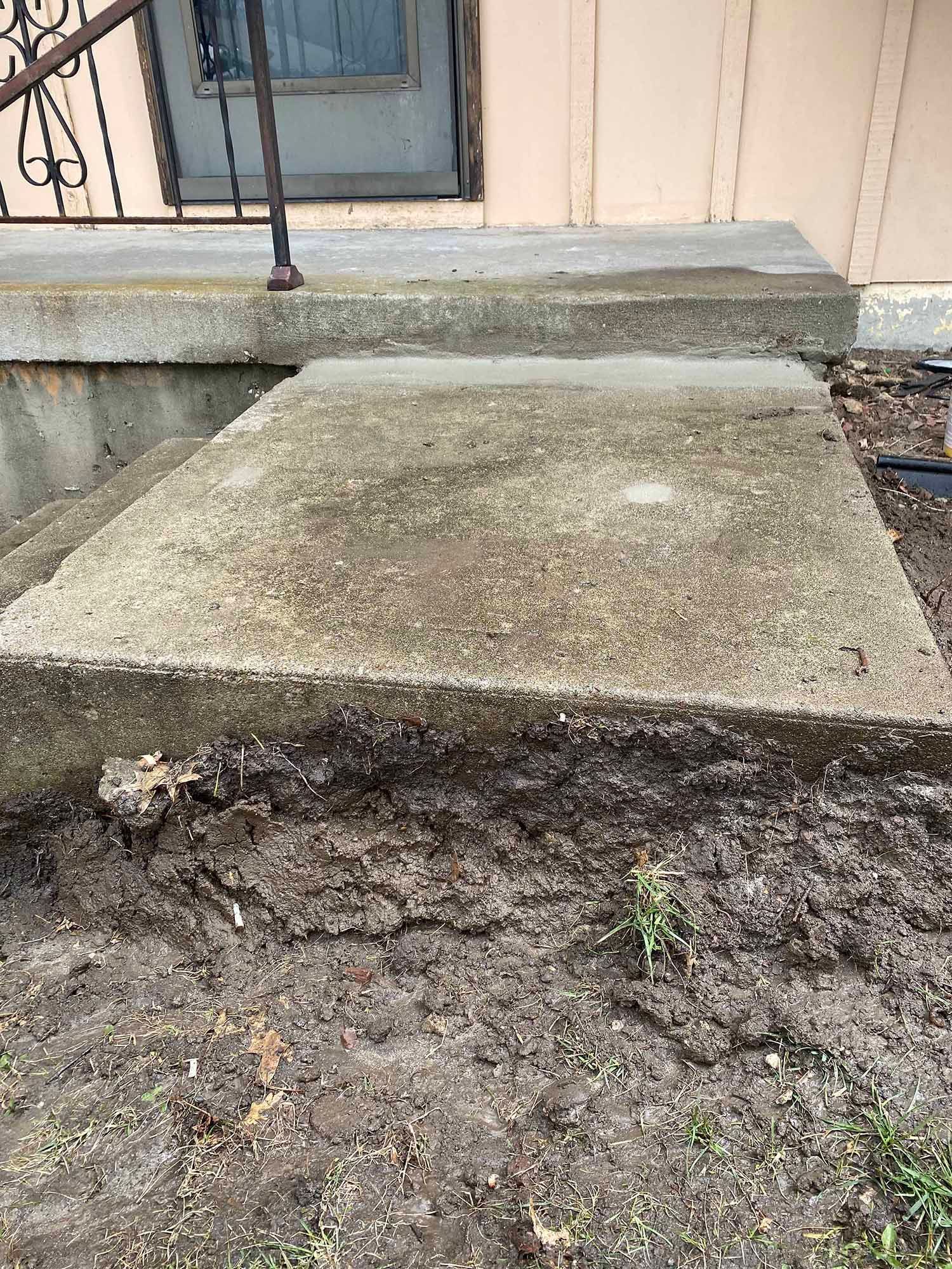 A concrete staircase is being built in front of a house.