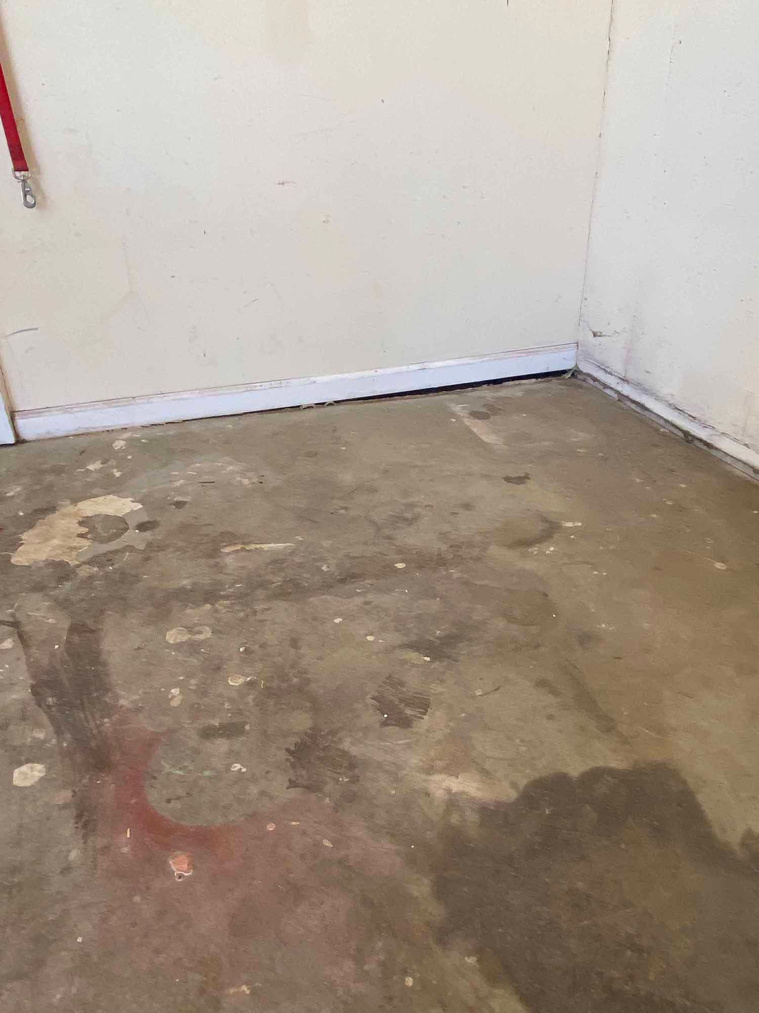 A room with a dirty floor and a white wall.