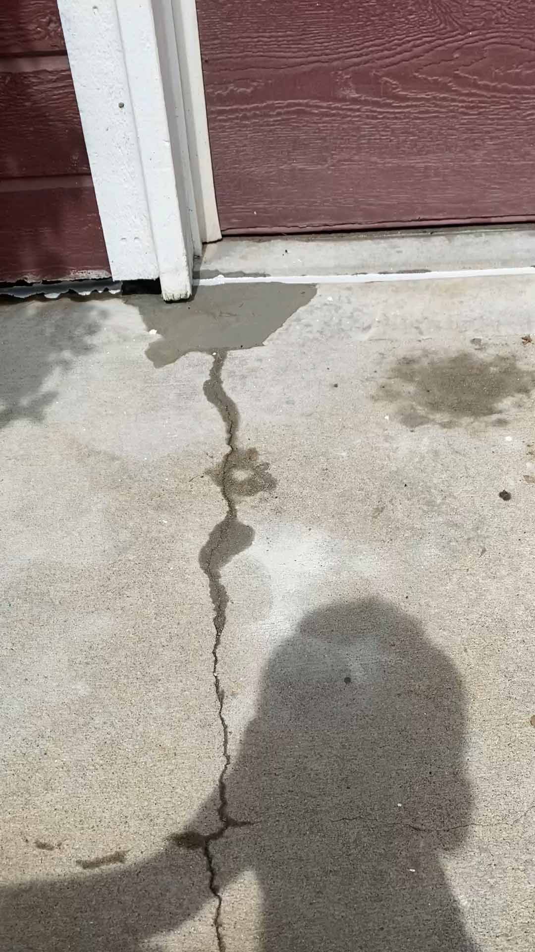 A cup of coffee with a straw is sitting on the sidewalk.