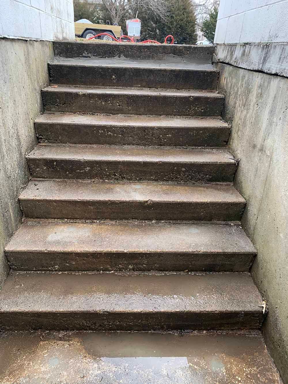 A set of concrete stairs leading up to a basement.