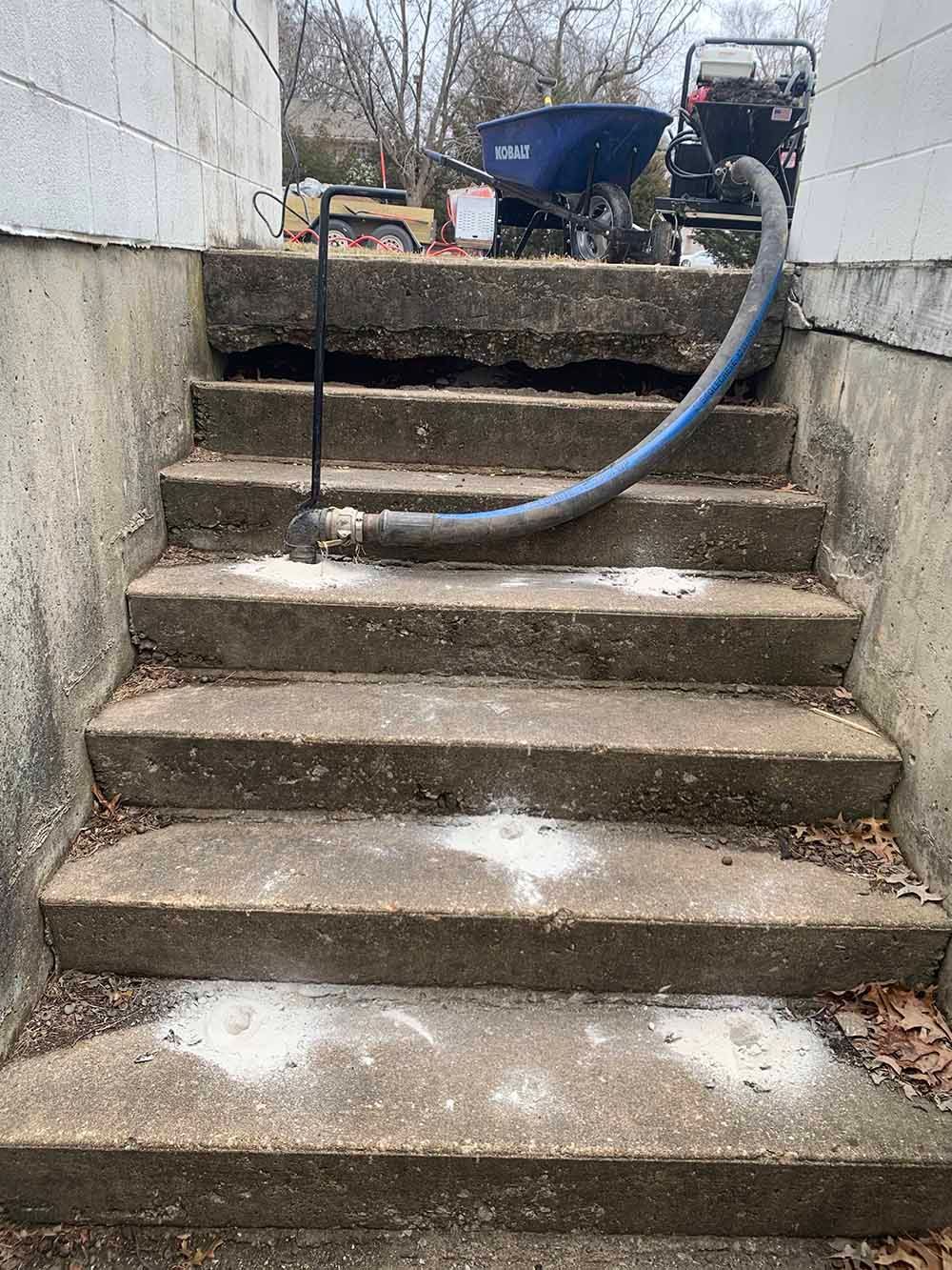 A hose is attached to a set of concrete stairs.