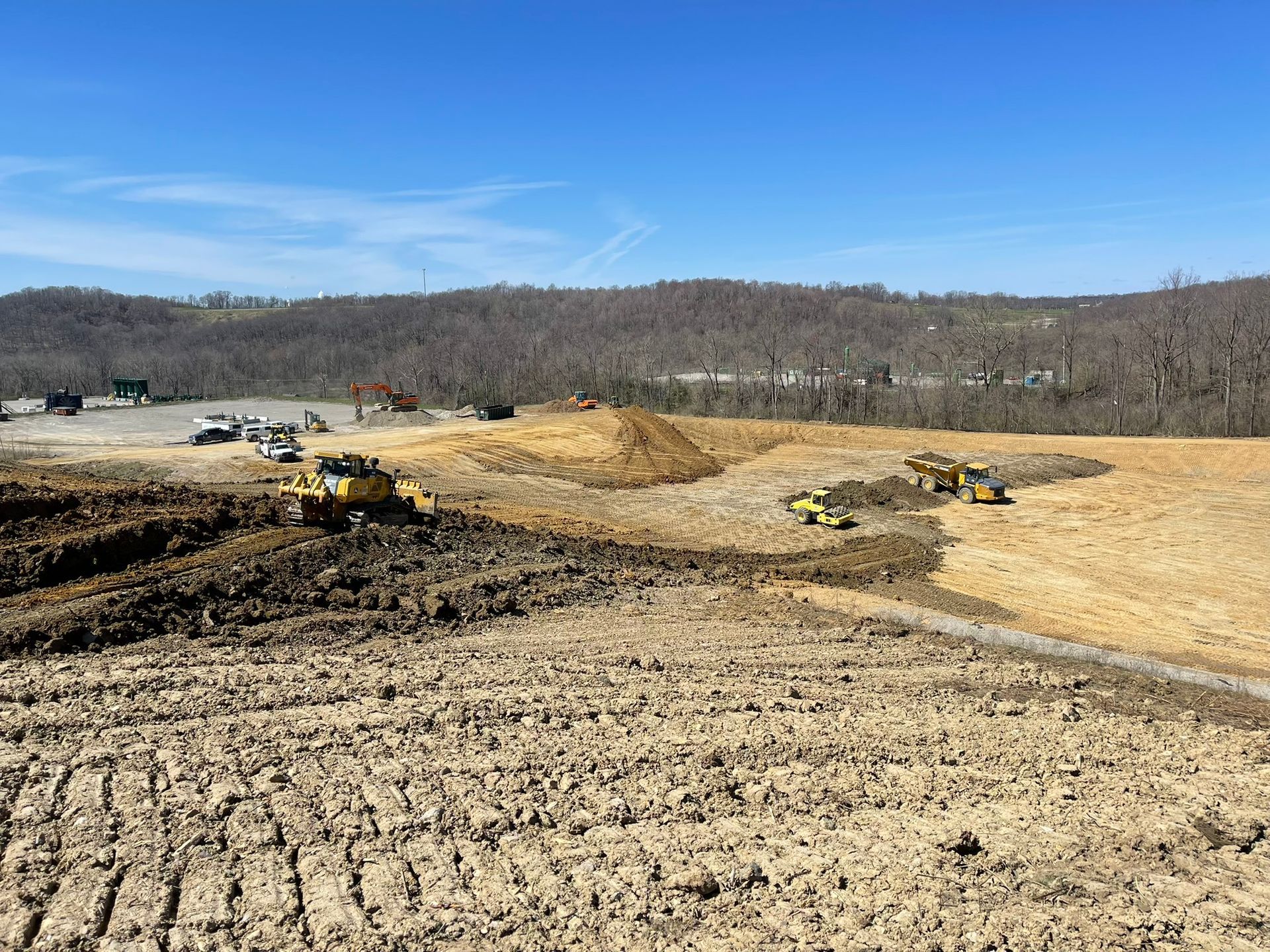 Construction site with bulldozers leveling dirt under a clear blue sky