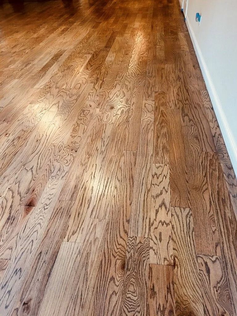 High-angle view of light brown, finished hardwood flooring with a visible wood grain pattern.