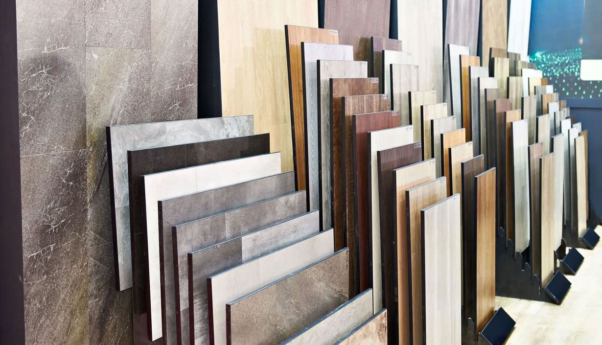 A showroom display featuring a diverse range of vertical stone, wood, and laminate tile samples organized in rows.