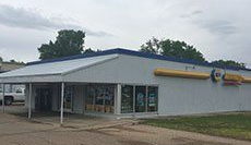 A white building with a blue roof and a canopy.