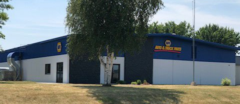 A large blue and white building with a tree in front of it.