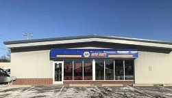 A white building with a blue sign on the front of it.